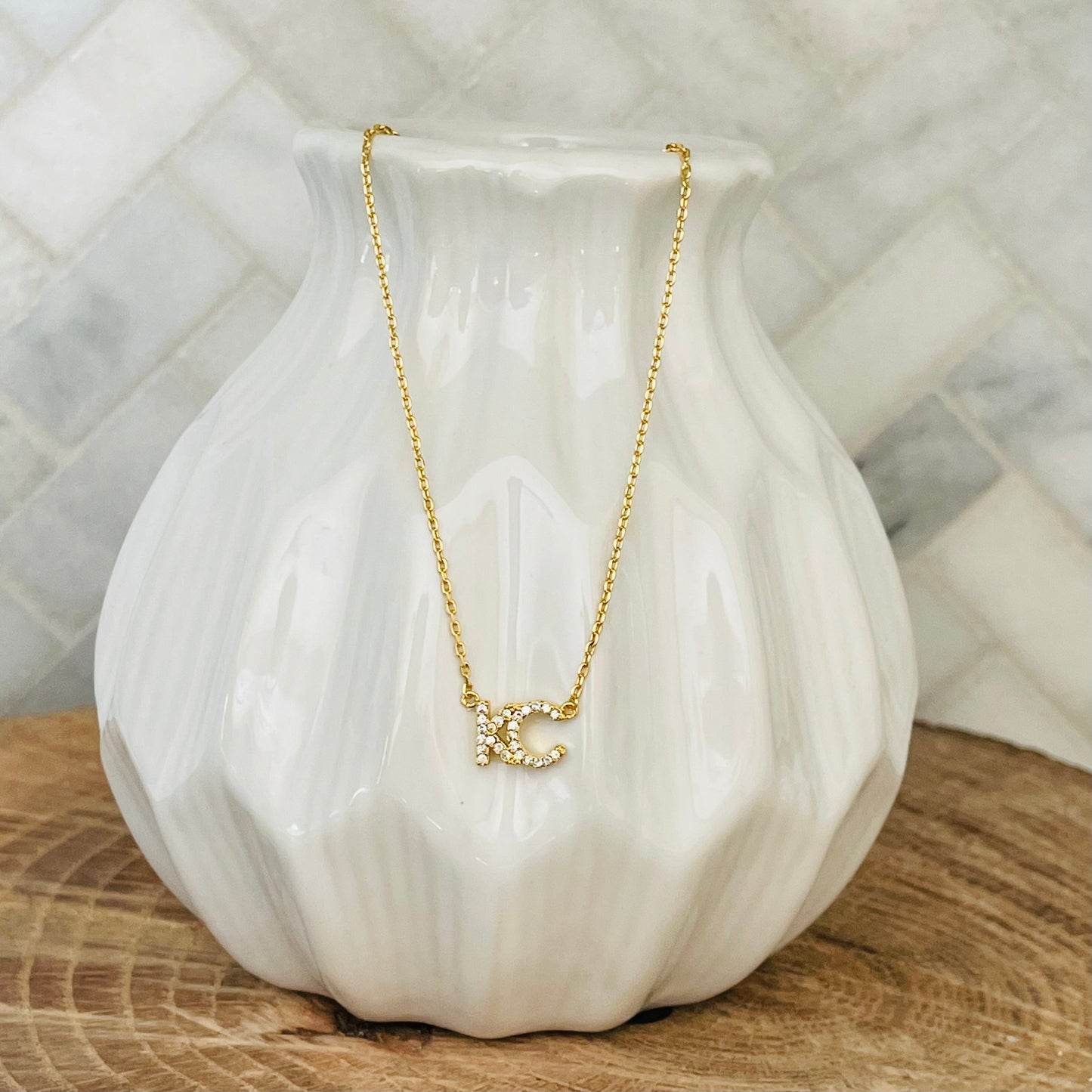 A little bit of KC love to take with you wherever you go. represent your hometown with this KC Rhinestone necklace. A simple and delicate design, this necklace is perfect for everyday wear. With its easy-to-wear style, this necklace is a must-have for any KC lover. KC Rhinestone Necklace 18K gold plated 18 inch necklace with 3 inch extender